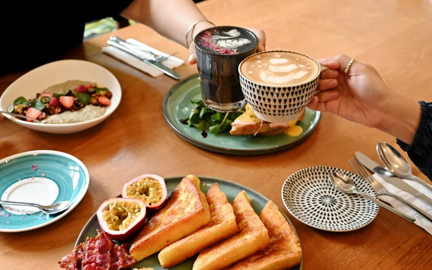 Bàn ăn brunch đầy ắp các món ăn hấp dẫn như bánh mì nướng kiểu Pháp, trái cây, yến mạch