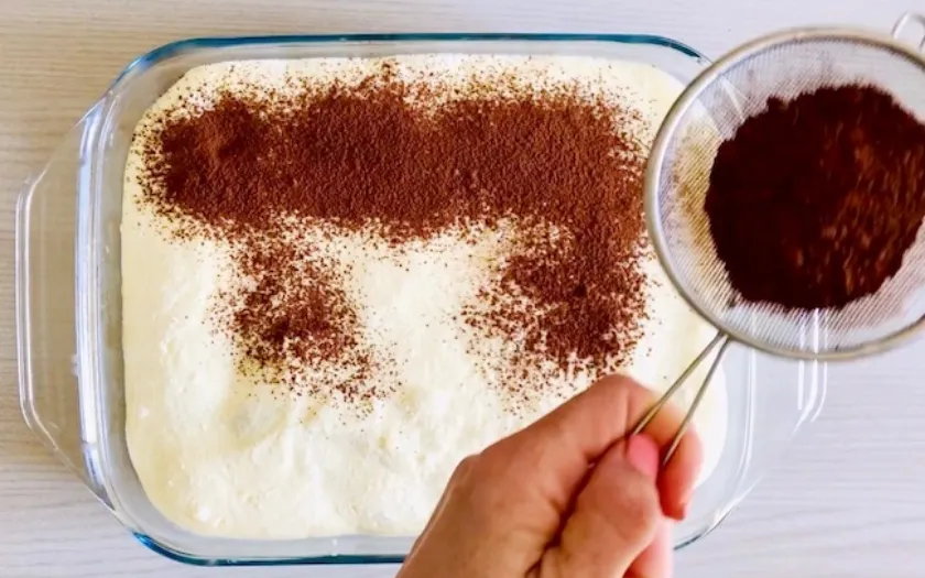 Dùng rây rắc bột cacao lên phần kem sẽ giúp lớp bột mềm mịn hơn