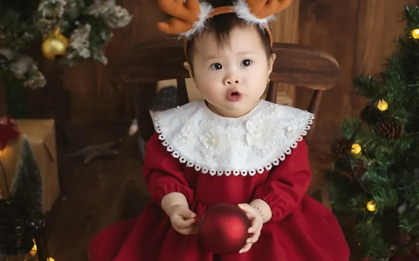 Nụ cười hồn nhiên của bé giữa không gian Giáng Sinh đầy màu sắc tạo nên khung hình thật đáng yêu