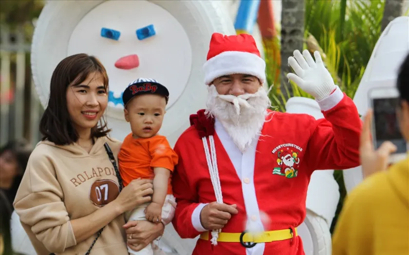 Các bạn nhỏ được bố mẹ dẫn đến thích thú chụp hình với ông già Noel