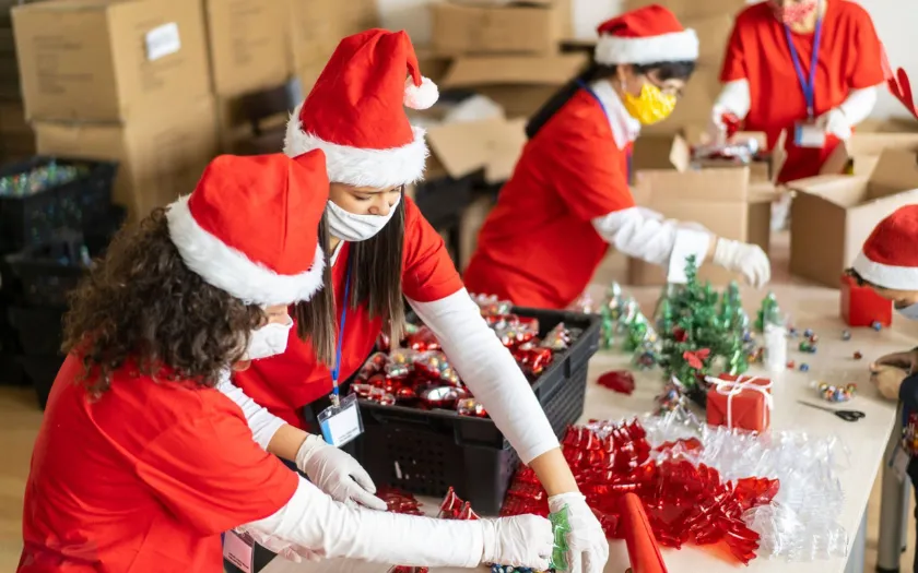 Nhân viên mặc trang phục ông già Noel cùng nhau đóng gói quà tặng Giáng sinh