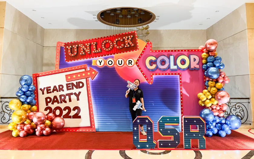 Backdrop gam màu neon và họa tiết Memphis tạo nên một không gian tiệc tất niên đầy năng lượng và sự bùng nổ