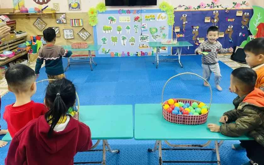 Bé giữ bóng trên thìa và di chuyển về đích