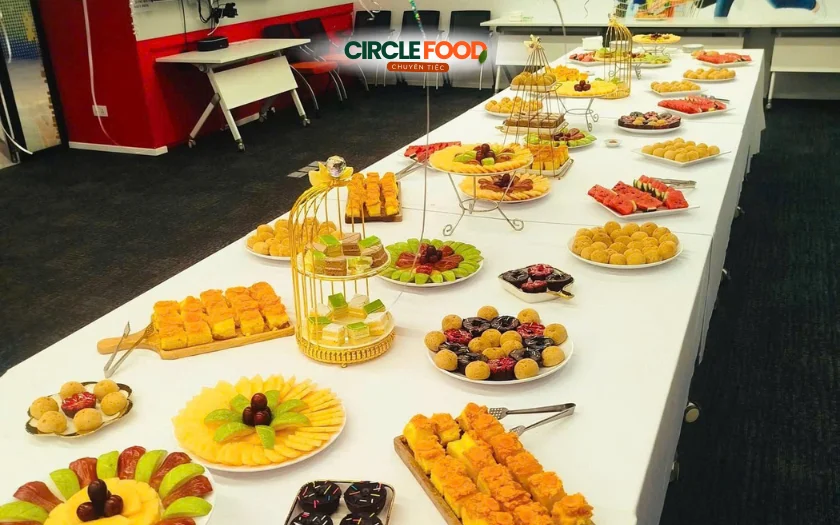 Bàn tiệc tea break được bày trí đẹp mắt với bánh ngọt, trái cây và món ăn nhẹ hấp dẫn