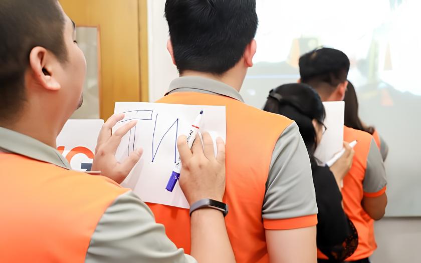 Nhân viên công ty tham gia trò truyền tin trong hoạt động team building (Nguồn: Internet)